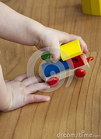 Wooden train in hands of a baby Stock Photo