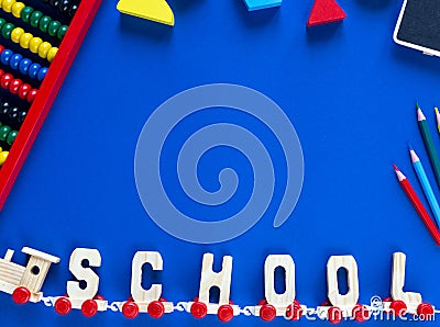 Wooden train with letters SCHOOL, pencils on classic blue background. Interesting, fun math for kids. Education, back to school Stock Photo