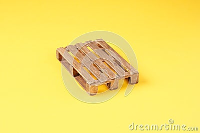 A wooden transport pallet on a yellow background Stock Photo