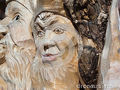 Wooden Tree Sculpture: Close-up of Faces Carved in Wood, Handmade Stock Photo