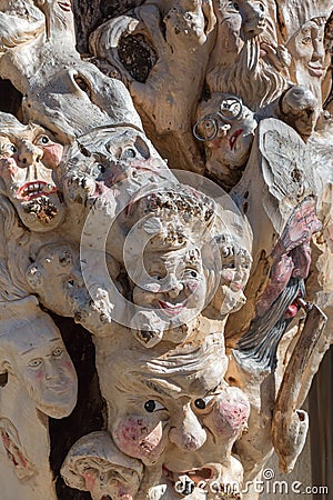 Wooden Tree Sculpture: Close-up of Faces Carved in Wood, Handmade Stock Photo