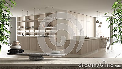 Wooden vintage table or shelf with stone balance, over blurred modern white kitchen with wooden details and parquet floor, feng Stock Photo