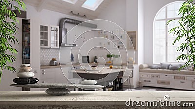 Wooden vintage table or shelf with stone balance, over blurred scandinavian kitchen with island and couch, feng shui, zen concept Stock Photo