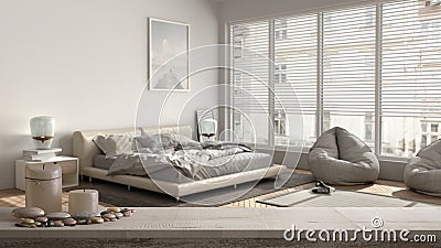 Wooden vintage table top or shelf with candles and pebbles, zen mood, over modern white and wooden bedroom with carpet, parquet, Stock Photo