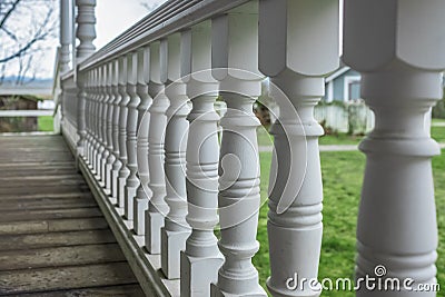 Wooden walkout deck with white railings outdoor in a beautiful garden. Wooden deck of a house with white railings Stock Photo