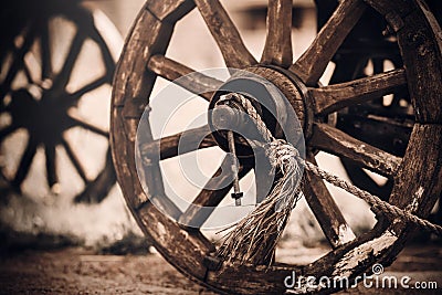 Wooden wheels of an old cart standing in the yard in a village in the countryside. Vintage objects of the past. History Stock Photo