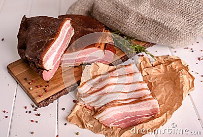 Smoked bacon sliced on a wooden cutting board. Close-up, selective focus. Stock Photo
