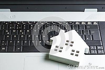 wooden white hose model on laptop notebook.Online shopping concept.Real estate concept, New house concept.Buying a house Stock Photo