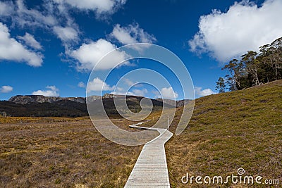 Wooden winding boardwalk in highlands of Cradle Mountain National park on bright sunny day. Tasmania, Australia. Stock Photo