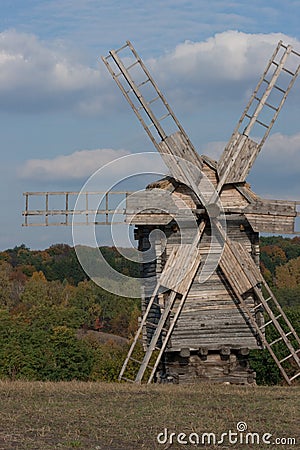 Wooden windmill. Autumnal forest. Stock Photo