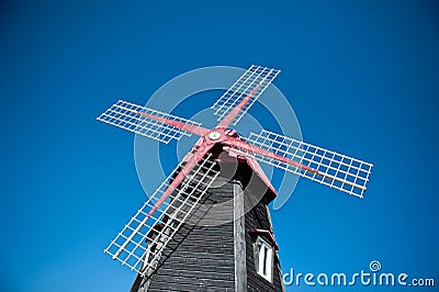 Wooden windmill with a blue sky background Stock Photo