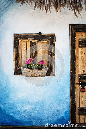 Wooden window with flowers, blue wall and door with padlock, retro style Stock Photo