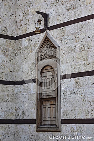 Wooden window of a mosque with an antique lamp hanging on top in the city of Yambu Stock Photo