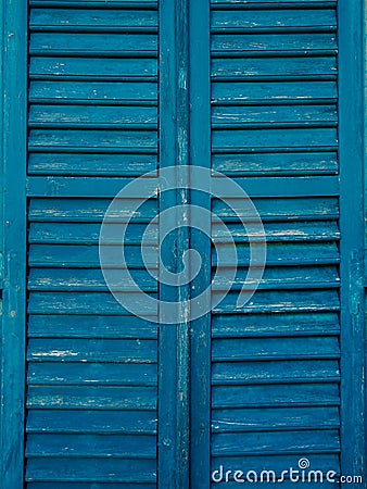 Wooden window shutters in blue. Antique homemade shutters on the Stock Photo
