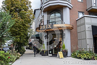 Woodinville, WA USA - circa September 2021: Street view of a woman walking by a Brix Wine Cafe in the Woodinville city center Editorial Stock Photo