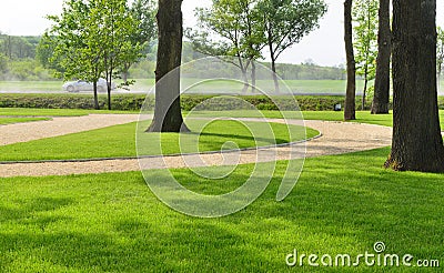 Woodland park with manicured lawns and a road Stock Photo