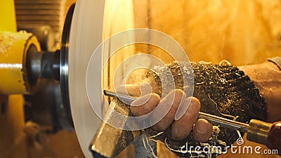 Woodworker handles product by lathe and graver Stock Photo