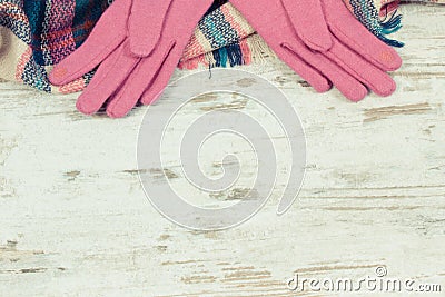 Woolen womanly pink gloves and colorful scarf, clothing for autumn or winter concept, place for inscription Stock Photo