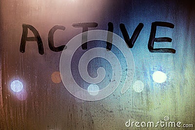 The word active written on night wet window glass close-up with bokeh background Stock Photo