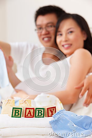 Word baby in front of asian couple Stock Photo