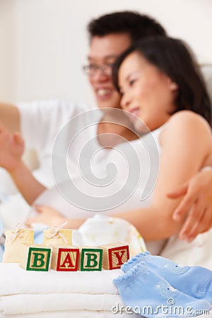 Word baby in front of asian couple Stock Photo