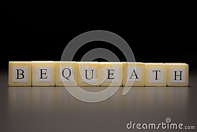 The word BEQUEATH written on wooden cubes isolated on a black background Stock Photo