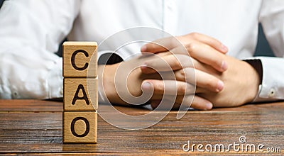 The word CAO and a man with locked hands. Chief Accounting Officer. Vacancy and duties of a specialist. Manage taxes and payroll Stock Photo