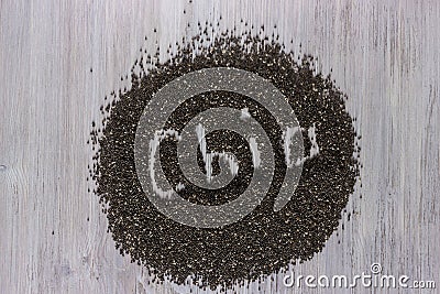 Word chia made from chia seeds on white wooden background. Healthy food. Stock Photo