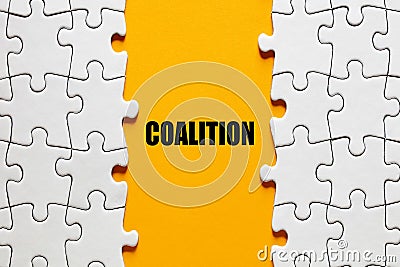 The word coalition between the jigsaw puzzle pieces. Alliance, cooperation and collaboration in business or politics Stock Photo