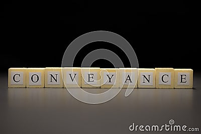 The word CONVEYANCE written on wooden cubes isolated on a black background Stock Photo
