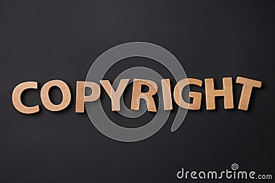 Word Copyright made of wooden letters on black background, flat lay. Plagiarism concept Stock Photo