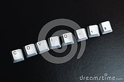 The word Covid-19 from the keyboard keys Stock Photo