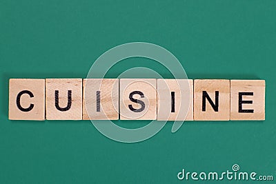 Word Cuisine from wooden letters on a green background Stock Photo