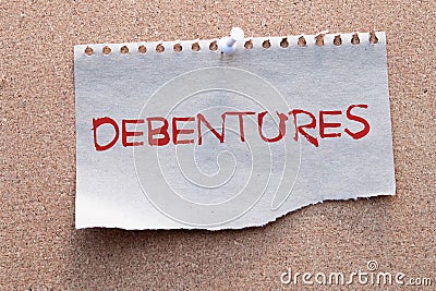 The word debentures in Brazilian Portuguese written on a piece of paper on a wooden table. Stock Photo