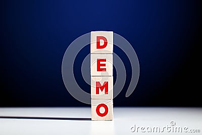 The word demo written on tiered wooden cubes against blue background Stock Photo