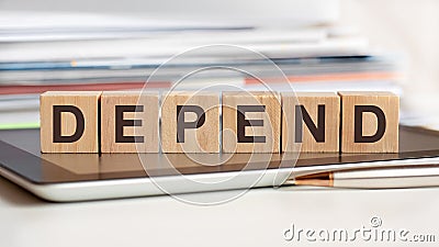 the word depend is written on wooden cubes, concept Stock Photo