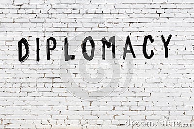 White wall with black paint inscription diplomacy on it Stock Photo