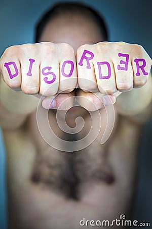 The word DISORDER written on the fists of a man Stock Photo