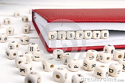 Word Dispute written in wooden blocks in red notebook on white w Stock Photo