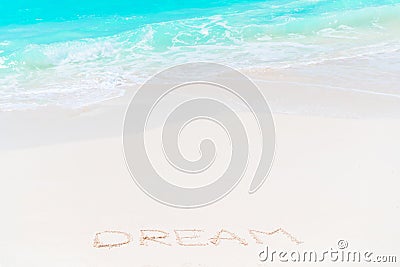 Word Dream handwritten on sandy beach with turquoise water Stock Photo