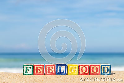 Word FEELGOOD in colorful alphabet blocks on tropical beach Stock Photo