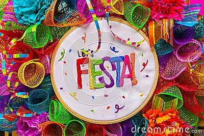 The word `fiesta` stitched in colorful letters on multicolored mash decorated with glitter and paper flowers Stock Photo