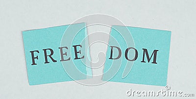 The word freedom is staning on a torn apart paper, new normal, covid-19 regulations, changing life Stock Photo