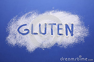 Word Gluten written with flour on blue background, top view Stock Photo