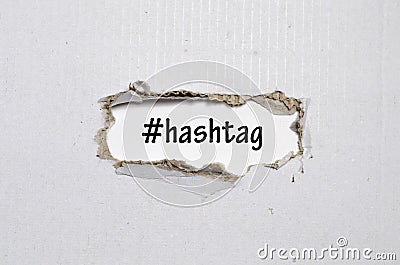 The word hashtag appearing behind torn paper Stock Photo