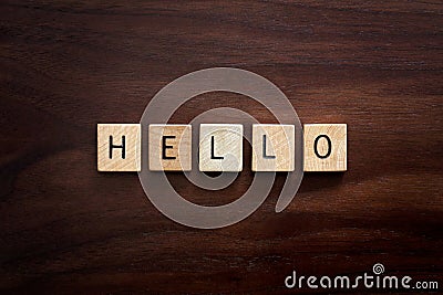 Words Hello Spelled out in Wooden Letter Blocks on Dark Walnut Wood Background Stock Photo