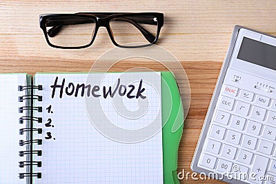 Word HOMEWORK in notebook, glasses and calculator on table, flat lay Stock Photo