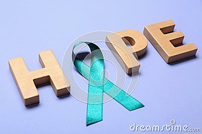 Word Hope made of wooden letters and teal awareness ribbon. Symbol of social and medical issues Stock Photo