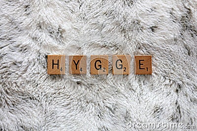 Word Hygge Spelled out with Wooden Letter Blocks on Soft Faux Fur Blanket Stock Photo