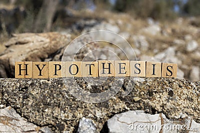 The word Hypothesis was created from wooden cubes. Photographed on the wall. Stock Photo